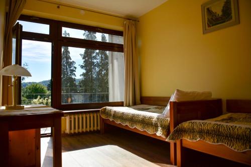 een slaapkamer met een raam, een bed en een bureau bij Apartamenty Argo in Krakau