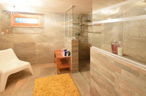 a bathroom with a shower and a sink and a chair at Relais del Sosto in Olivone