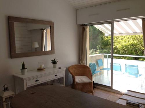 - une chambre avec une table, un miroir et un balcon dans l'établissement 18 Rue de la Corvette, à Saint-Palais-sur-Mer