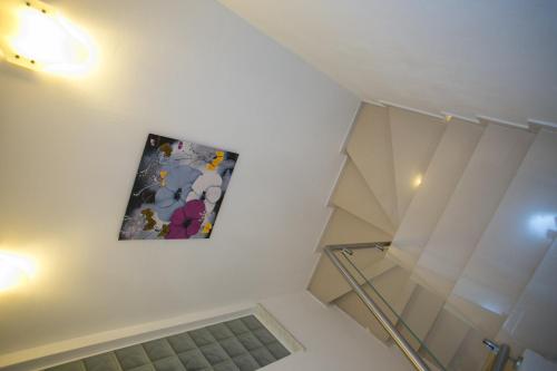 a painting hanging on a wall next to a glass staircase at Agata Apartments in Novalja