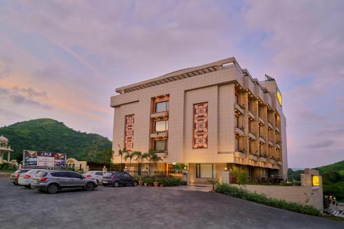 a building with cars parked in a parking lot at SKK Blu Hotel & Spa in Udaipur