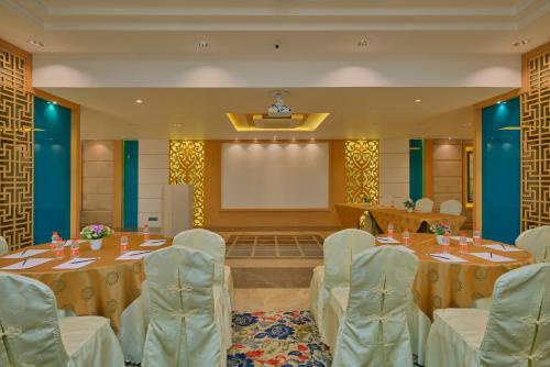 a conference room with tables and chairs and a screen at SKK Blu Hotel & Spa in Udaipur