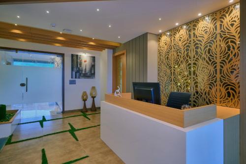 a lobby with a reception desk and a wall with a pattern at SKK Blu Hotel & Spa in Udaipur