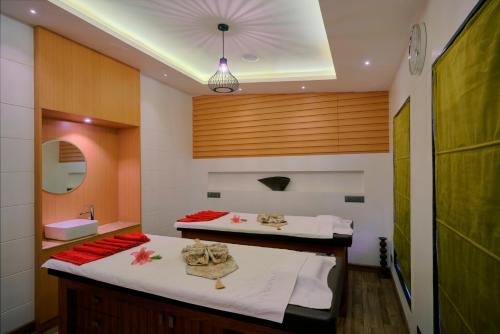 two beds in a bathroom with a sink and a mirror at SKK Blu Hotel & Spa in Udaipur