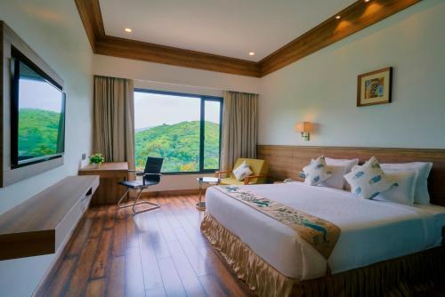 a bedroom with a large bed and a large window at SKK Blu Hotel & Spa in Udaipur