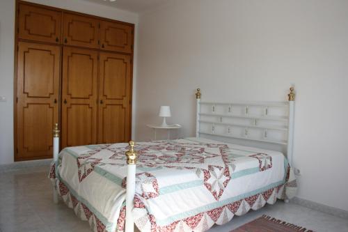 ヴィラ・ノヴァ・デ・ミルフォンテスにあるSummer Comfortのベッドルーム1室(ベッド1台付)、木製キャビネットが備わります。