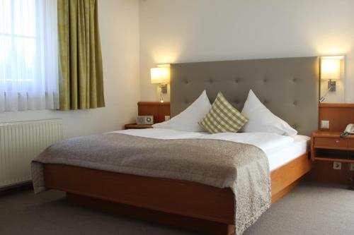 una camera con un grande letto in una camera d'albergo di Seehotel Paulitsch a Velden am Wörthersee
