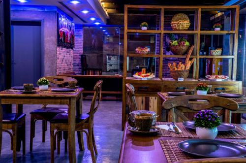 Flowery Holiday Suites في الكويت: غرفة طعام مع طاولات وكراسي خشبية