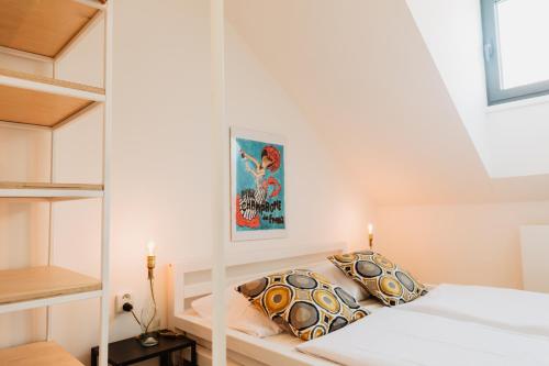 a small bedroom with a white bed and shelves at Street Food Possonium Apartments in Bratislava