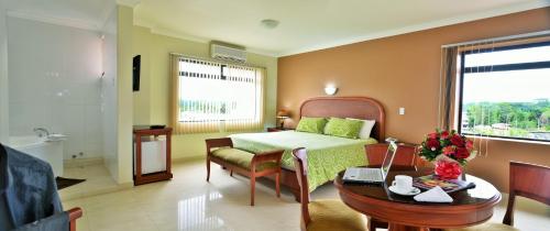 Schlafzimmer mit einem Bett, einem Schreibtisch und einem Tisch in der Unterkunft Gran Hotel De Lago - Lago Agrio in Nueva Loja