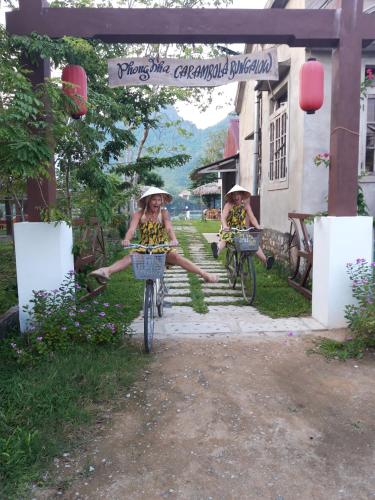 two girls are riding bikes down the stairs at Carambola Bungalow in Phong Nha