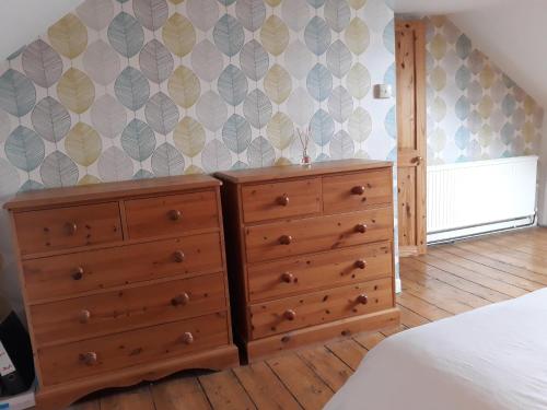 a bedroom with a dresser and a wall at Allington Hill-Bridport, Dorset in Bridport