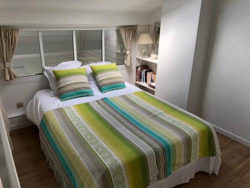 a bedroom with a large bed with two pillows at 18 Rue de la Corvette in Saint-Palais-sur-Mer