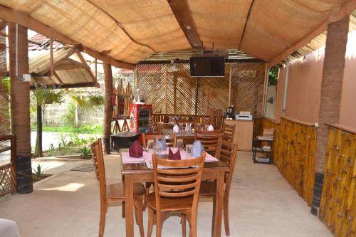 a restaurant with a table and chairs and a television at Hotel Thilon in Katunayaka