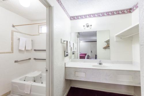 a white bathroom with a sink and a mirror at Knights Inn Hurricane Mills in Hurricane Mills