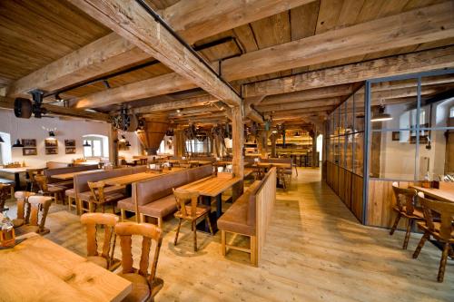 un restaurante con suelo de madera, mesas y sillas en Hotel Kunstmühle, en Mindelheim