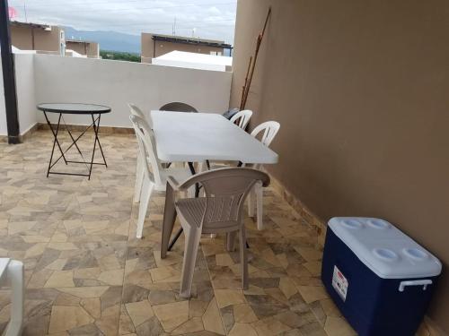 a white table and chairs and a table and a trash can at Aprtamento Deluxe Santiago, Residencial Palma Real R402 in Santiago de los Caballeros