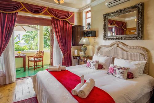 a bedroom with a bed with two stuffed animals on it at Stadium Guest House in Cape Town