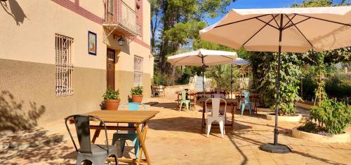 a patio with tables and chairs and an umbrella at Casa de Los Lirios in Muro de Alcoy