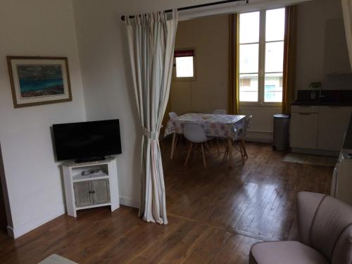 sala de estar con TV y mesa con sillas en Plage et centre en Villers-sur-Mer