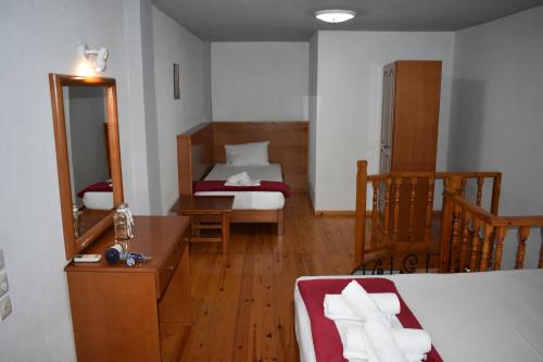 a hotel room with two beds and a mirror at Galanis Studios and Apartments in Platamonas