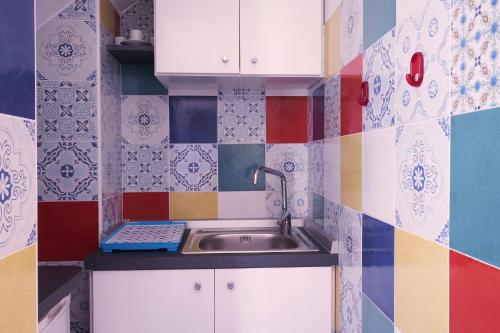 ナポリにあるNeapolitan Houseのカラフルなタイルのキッチン(シンク付)