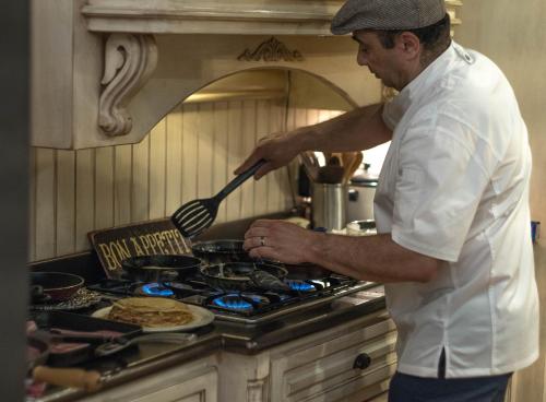 een man die met een spatel op een fornuis aan het koken is bij The Victoria Bed & Breakfast in Bentonville