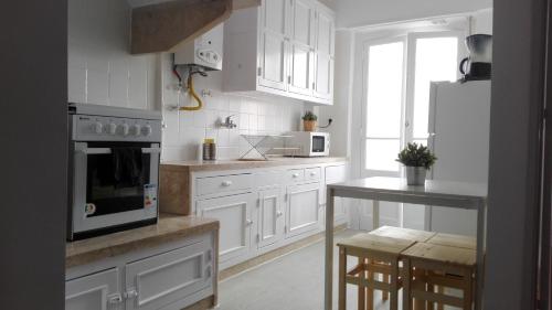 a kitchen with white cabinets and a stove top oven at Golden Apartment City Center in Lisbon
