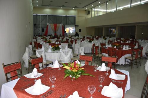 a large banquet hall with white tables and chairs at Gran Hotel De Lago - El Coca in Puerto Francisco de Orellana