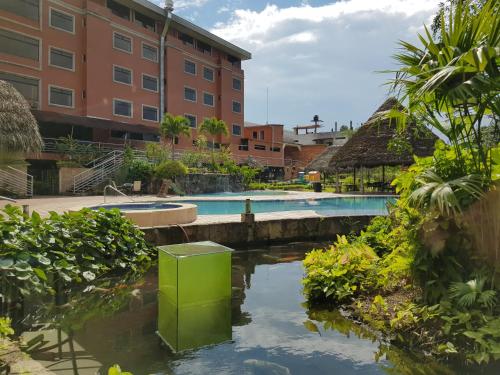 a swimming pool in a resort with a building at Gran Hotel De Lago - El Coca in Puerto Francisco de Orellana