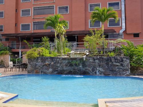 a swimming pool in front of a building at Gran Hotel De Lago - El Coca in Puerto Francisco de Orellana