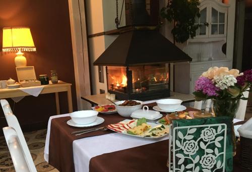a table with food and a fireplace in a room at Stajnia Sarnówek Nad Jeziorem Różany in Rozajny Wielkie