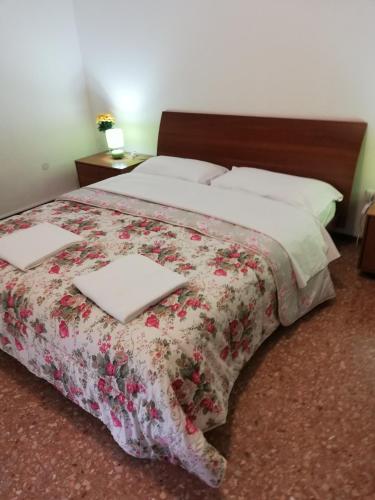 a bedroom with a bed with a floral bedspread at Venice Best Vacation in Marghera