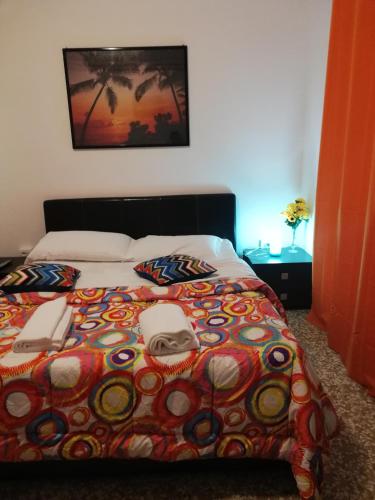 a bed with a colorful comforter with two phones on it at Venice Best Vacation in Marghera