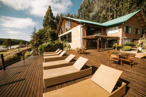 een terras met ligstoelen en een huis bij Virá Charme Resort in Fernandes Pinheiro