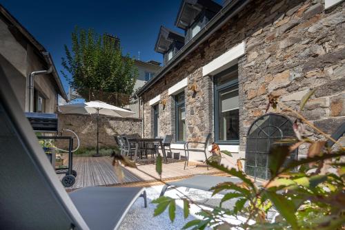a patio with a table and chairs and a building at Le Cosy de Claire in La Bourboule