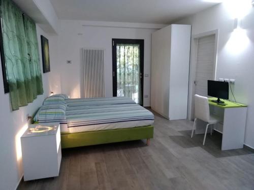 a bedroom with a bed and a desk and a computer at "CARA PACE" in collina - Guest House in Montefiore Conca