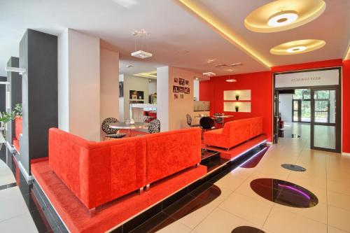 a lobby with orange furniture and red walls at Hotel Zacisze in Turawa