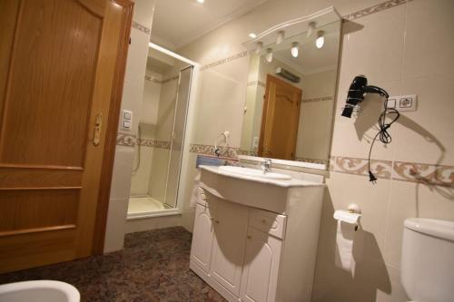 a bathroom with a sink and a toilet and a mirror at La Muralla Del Castillo in Chulilla