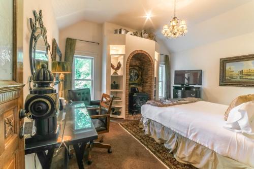 a bedroom with a bed and a desk and a chair at The Victoria Bed & Breakfast in Bentonville