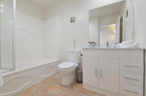 奧克蘭的住宿－Wendy‘s，白色的浴室设有卫生间、浴缸和水槽。