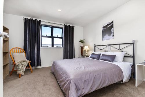 sypialnia z łóżkiem, krzesłem i oknem w obiekcie Wendy‘s w Auckland