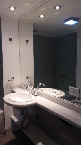 a bathroom with a sink and a large mirror at Rosario Paladium Apartment in Rosario