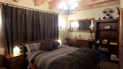 a bedroom with a bed and a chandelier at Tree House Lodge Bed & Breakfast in Cheviot