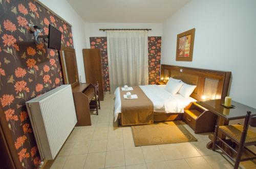 a hotel room with a bed and a desk at Rodavgi in Kato Loutraki
