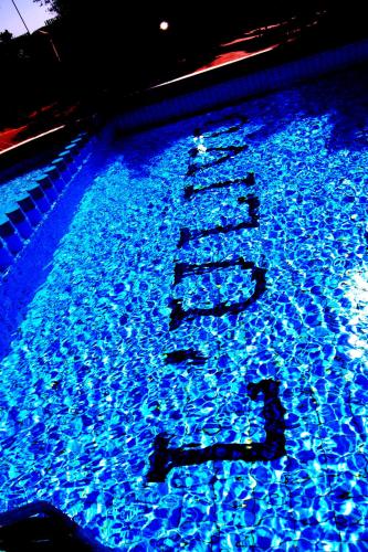 a pool of blue water with a sign in it at Hotel L'Ulivo in Girasole