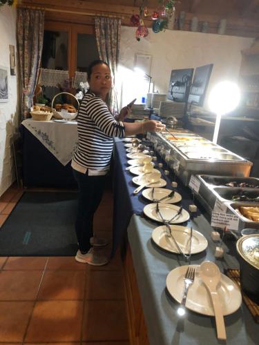a young girl standing at a buffet line with plates at PAGA Hotel in Aidenbach