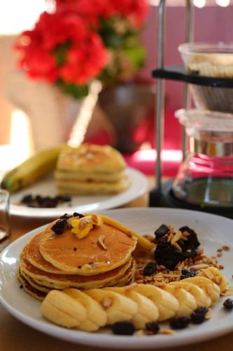 two plates of pancakes and bananas on a table at Baan JaoKorKluay บ้านเจ้ากอกล้วย in Chiang Rai