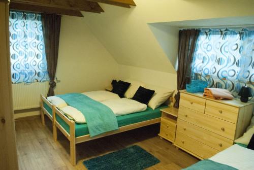Schlafzimmer mit einem Bett, einer Kommode und Fenstern in der Unterkunft Apartmany Silverado in Horní Bečva