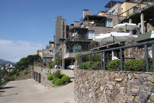 a stone wall with umbrellas in front of a building at Suite Duplex special Amarras Reales in Piriápolis